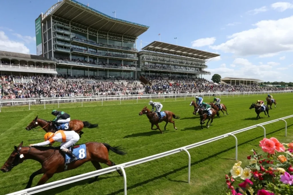 Horse race in progress with spectators watching from a multi-tiered stadium